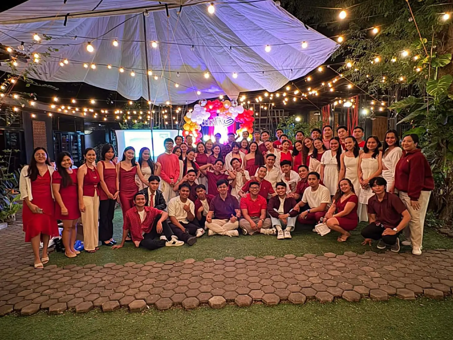 The whole Seighton BPO team together at an evening company celebration under string lights
